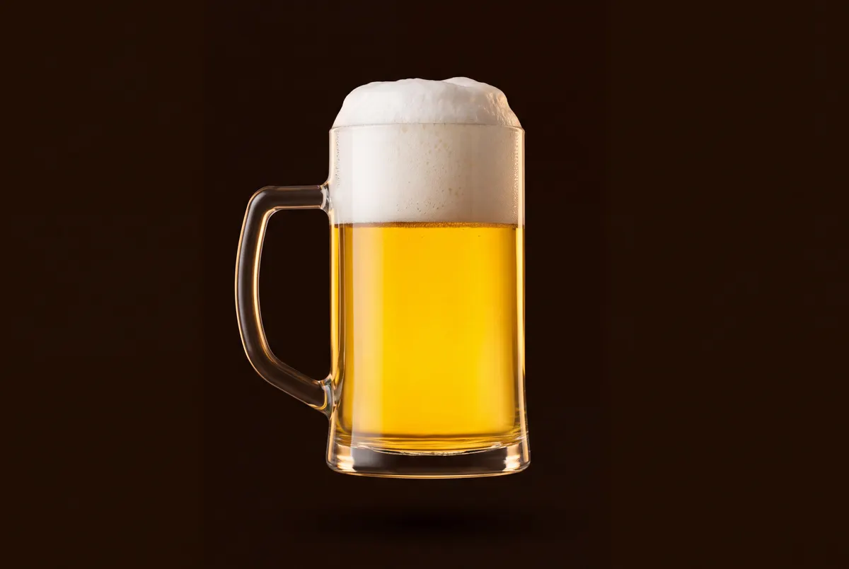 Verre droit tchèque rempli d’une pils dorée sous une mousse épaisse.